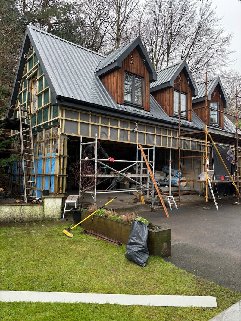 Large-scale loft conversion under construction with new roof structure and dormers